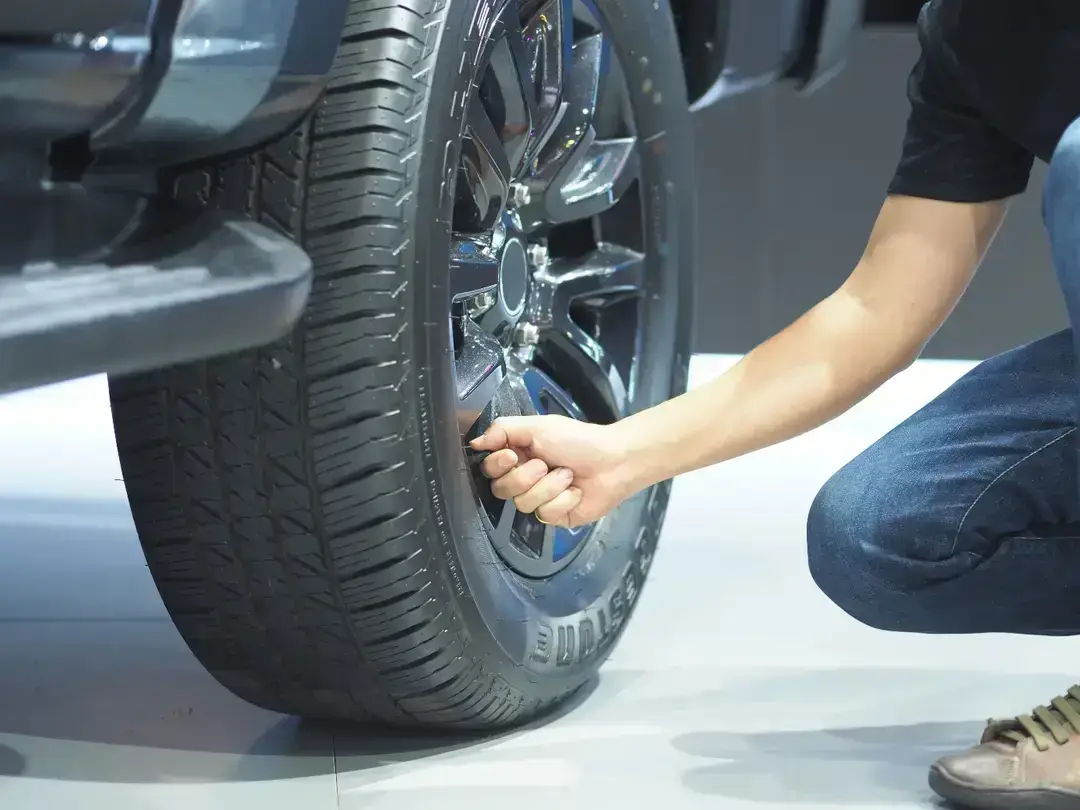 Person checking car tire pressure