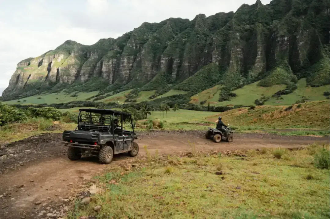 ATV and UTV on dirt trail by cliffs