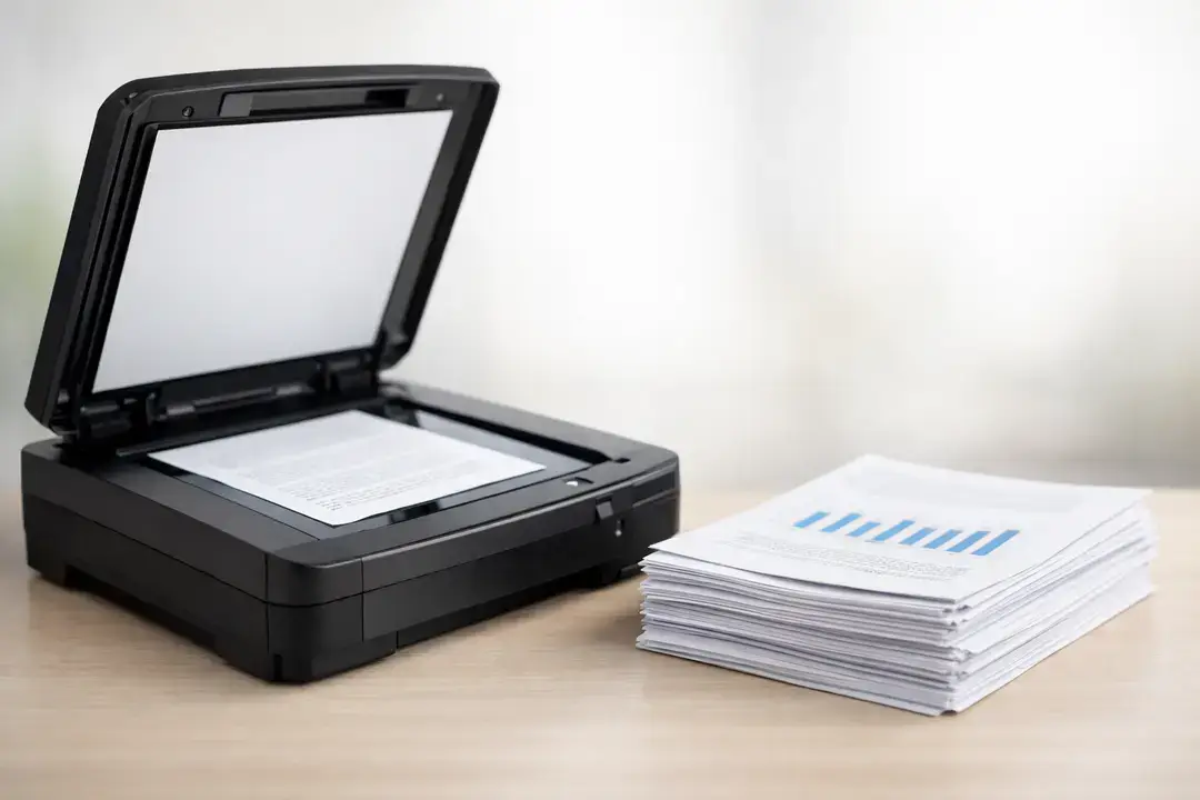 Flatbed scanner beside stacked papers