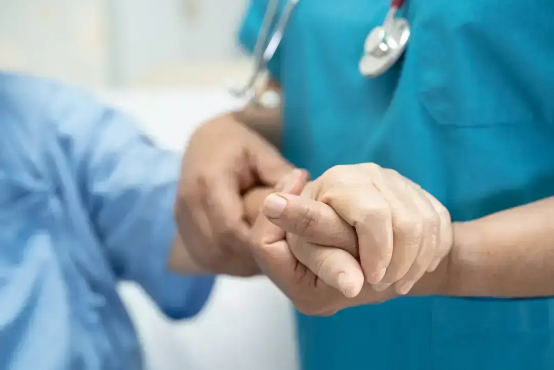 Nurse holding a patient's hand