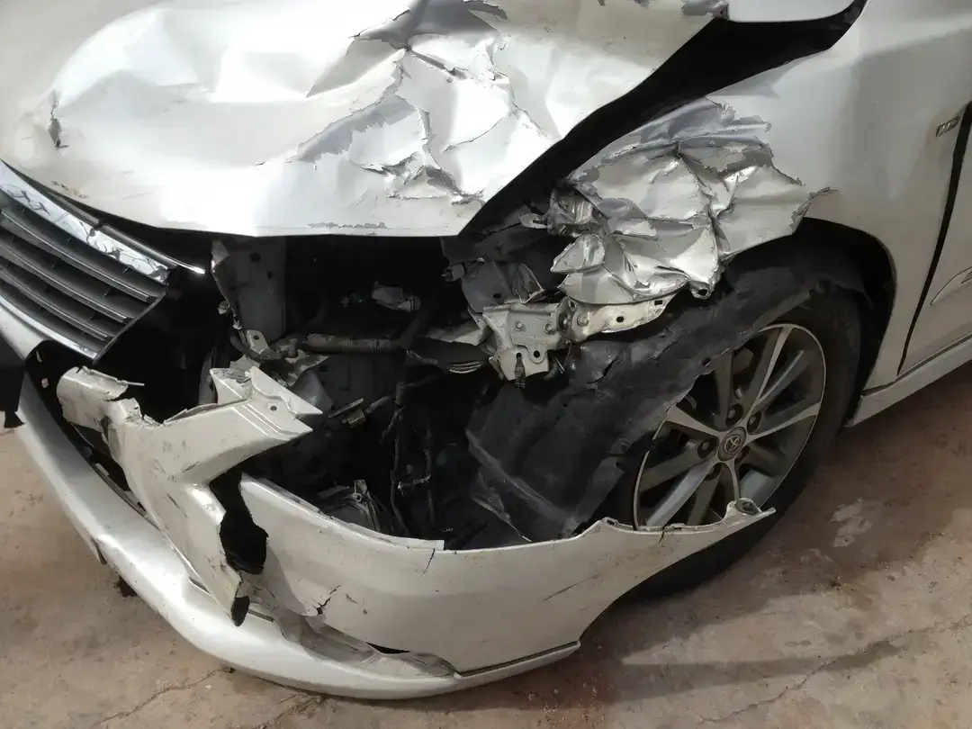 Damaged front end of white car