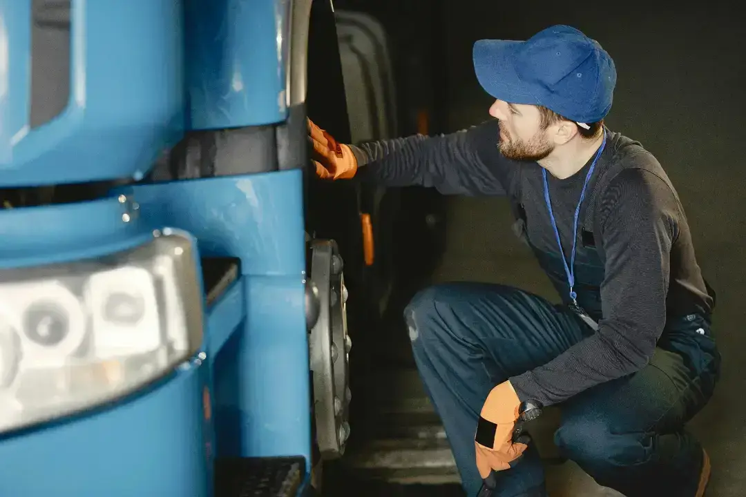 Mechanic inspecting a blue truck