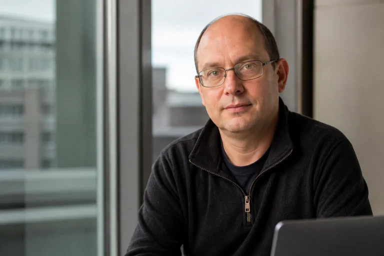 Man with glasses sitting by window