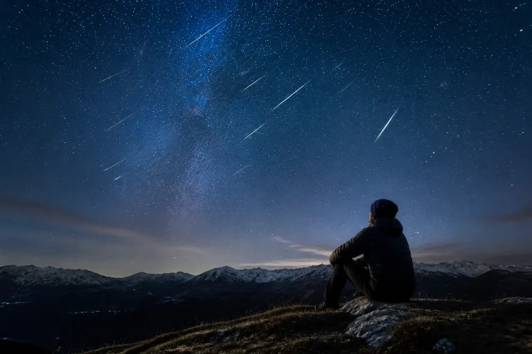 Person watching meteor shower at night